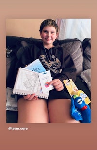 a boy sitting on a couch holding a book and a toy